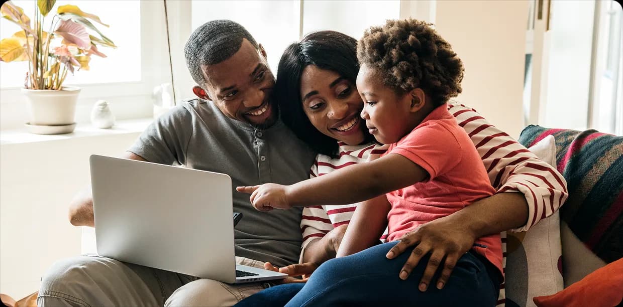 Family using laptop together on a couch